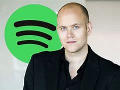 A man standing in front of a green spotify logo.