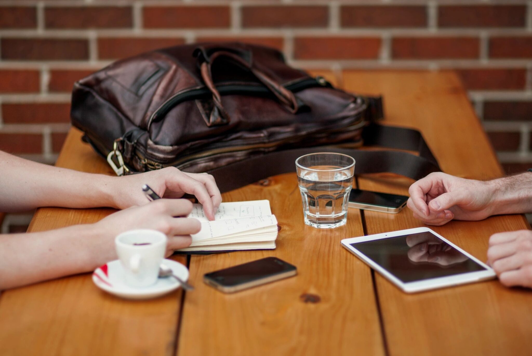 A wooden table with two people sitting at it