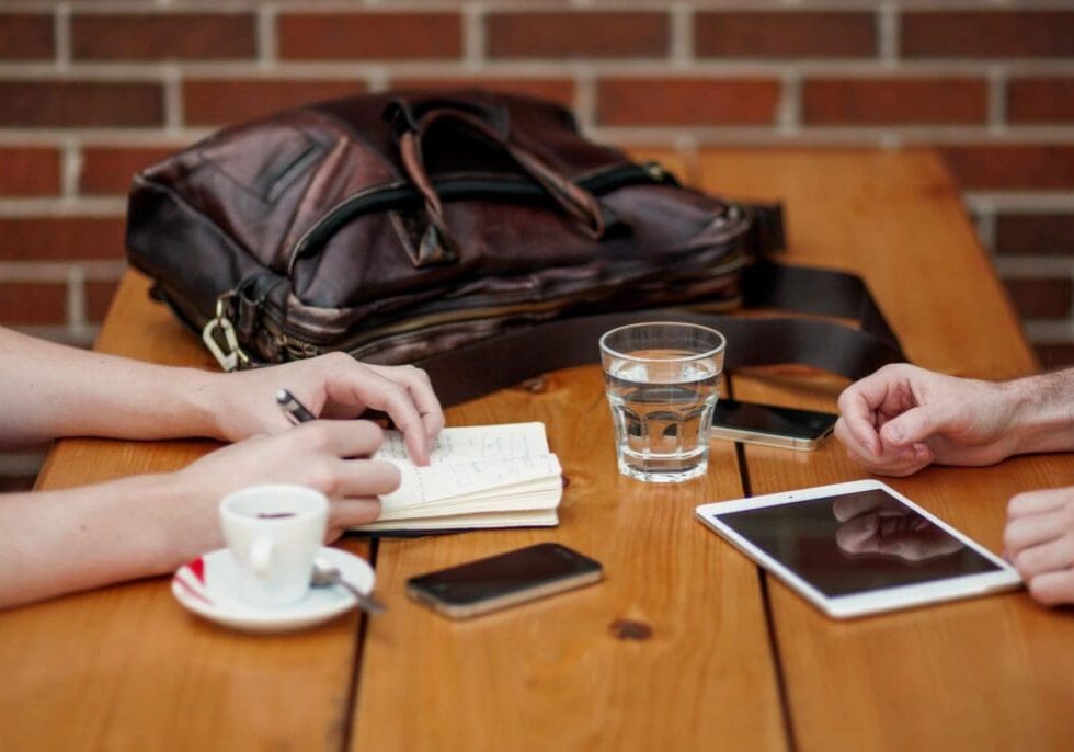 A wooden table with two people sitting at it