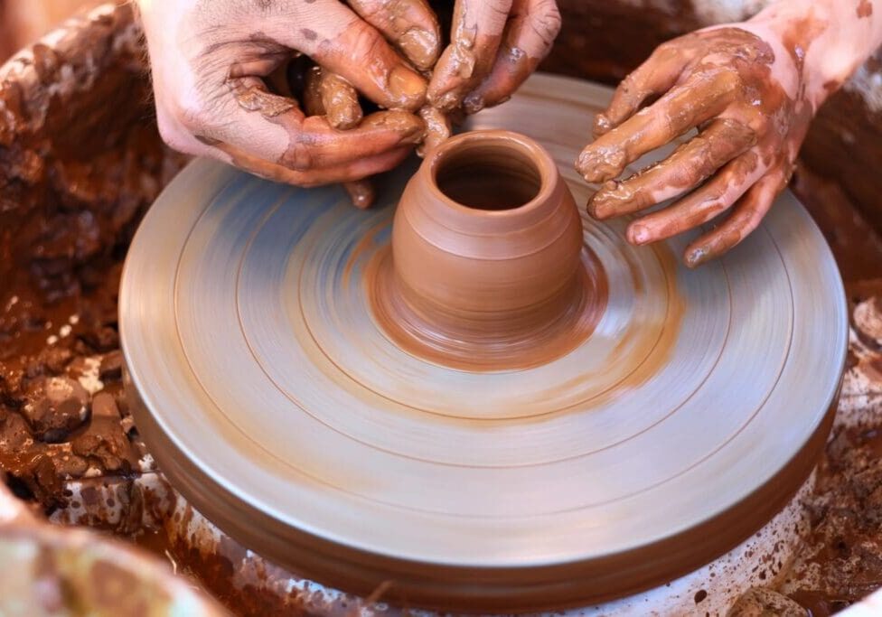 A person is making pottery on the potter 's wheel.