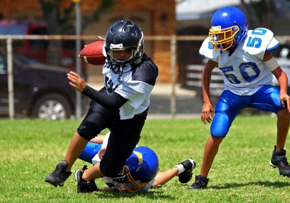 A group of young people playing football on the field.